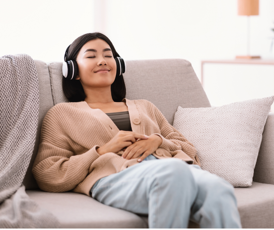 Woman with headphones lying back on a couch, completely relaxed